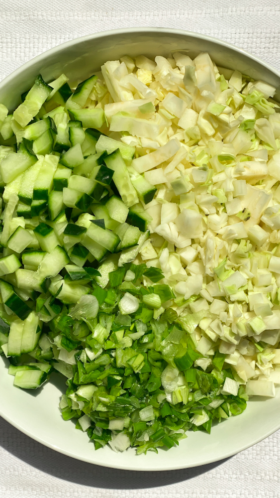 diced cabbage, cucumber and green onions in a bowl