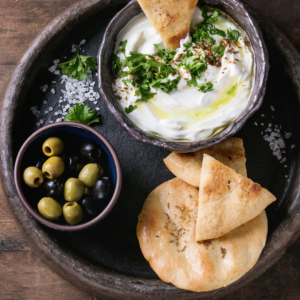 image of whipped cottage cheese with pita chips and olives