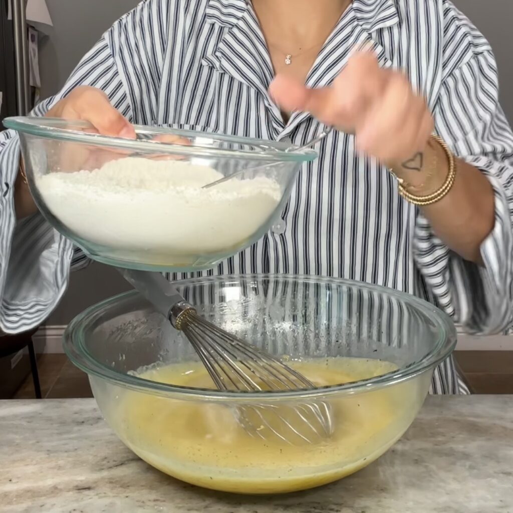Adding the dry ingredients to the wet ingredients for lemon olive oil cake