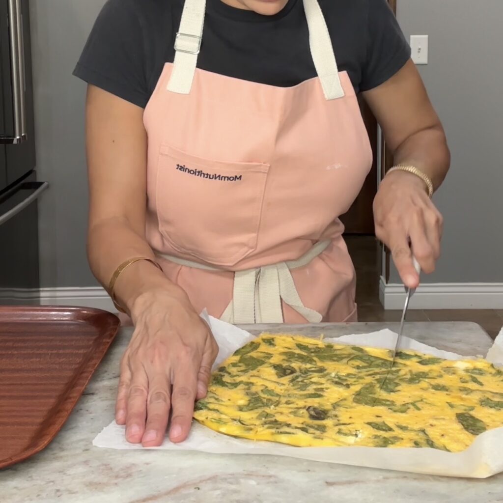 Cutting sheet pan eggs for meal prep breakfast burritos.